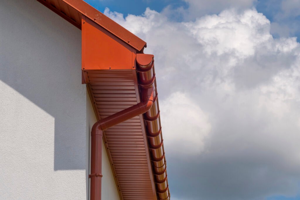 A metal roof of the house and a drain. Close-up side view.